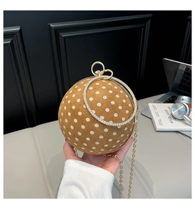 Macro detail of a spherical mini bag with polka dot texture and diamond-set gold handles