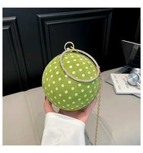 Detail of green polka dot sphere handbag with rhinestone ring handle and gold chain strap