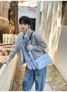 Close-up of a light blue nylon crossbody bag styled with casual denim and knitwear