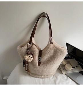 Détail du sac seau beige en fausse fourrure avec breloque ours léopard et bandoulière cuir