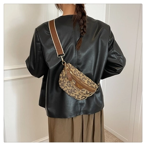 Close-up of leopard print chest bag with brown leather trim and golden logo plate