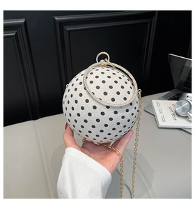 Detailed view of spherical polka dot evening bag with gold ring handle and chain