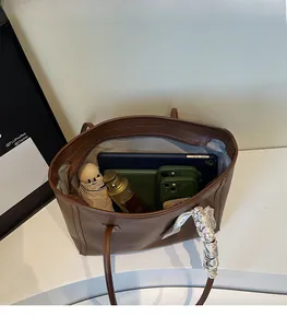 Macro detail of brown leather tote bag interior showing large capacity for essentials