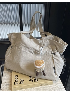Sac fourre-tout minimaliste en nylon beige avec grandes poches et breloque peluche