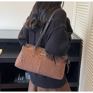 Detail showing vintage leopard print tote bag with soft suede texture and leather strap