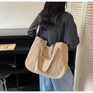 Khaki nylon draagtas met verstelbare schouderband gedragen door een model in kamer