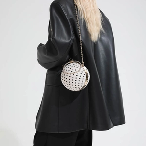 White spherical crossbody bag with black polka dots and gold rhinestone handle