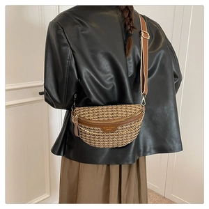 Detail of crossbody bag with houndstooth fabric, brown leather trim, and gold chain strap