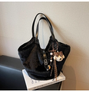Détail du sac seau en peluche noire avec breloque ours et poignées en similicuir
