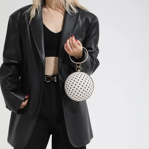 Polished round ball evening clutch with black dots and crystal metal handle on model