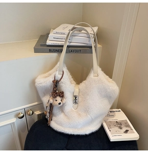 Détail du sac cabas en fausse fourrure blanche avec anses en cuir et breloque ours