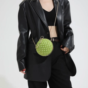 Detailed view of spherical green polka dot chain bag on professional model style