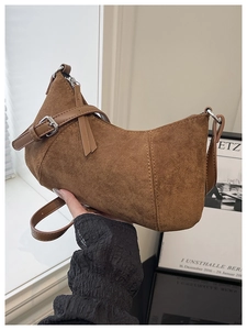 Detailansicht einer braunen Wildleder-Satteltasche mit schicken Lederquasten und Gurt