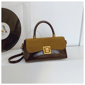Detail der Vintage-Henkeltasche mit grüner Wildlederklappe, braunem Leder und Goldverschluss