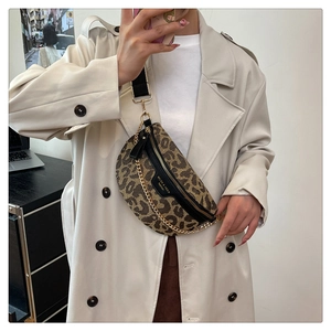 Detail view of leopard print crossbody bag with wide strap and gold chain accessories