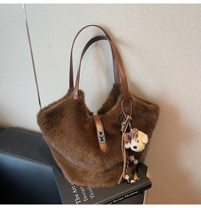 Détail du sac seau en fausse fourrure marron foncé avec bandoulière en cuir et ourson