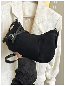 Detail der schwarzen Wildleder-Halbmondtasche mit Lederriemen und Silberschnalle