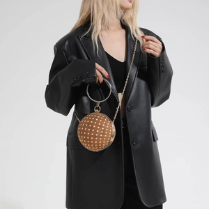 Polka dot ball clutch bag with crystal handle shown on a black leather jacket