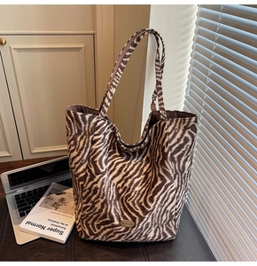 Close-up of zebra pattern tote bag with vintage handmade metal label and soft texture