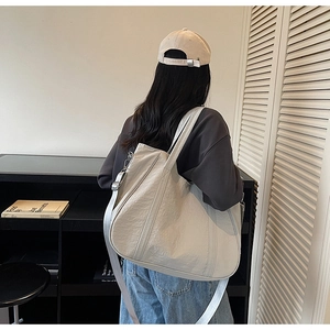 Detailopname van een grote shopper van gewassen stof met een verstelbare schouderriem