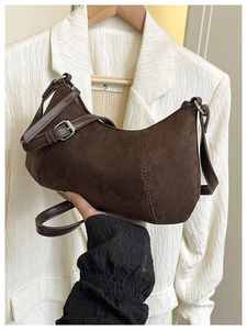 Details der braunen Wildleder-Hobo-Tasche mit Schnalle und Metall-Reißverschluss im Retro-Stil