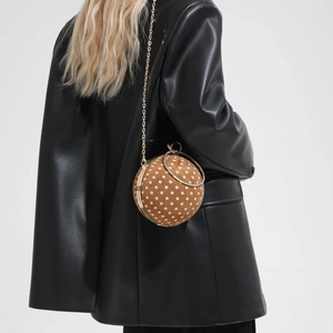 Macro detail of sphere crossbody bag with brown suede polka dots and gold diamond handle