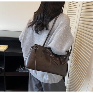 Detail of dark brown matte vintage shoulder bag featuring decorative drawstring bow
