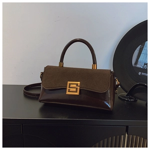 Details der dunkelbraunen Handtasche mit Wildlederklappe, Lackleder und goldener Schnalle
