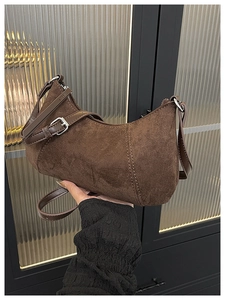 Detail der braunen Wildleder-Halbmondtasche mit matter Vintage-Textur und Silberschnalle