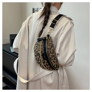 Detail of leopard print chest bag with adjustable wide strap and gold chain on model