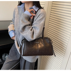 Detail of retro dark brown leather tote with 'Sunny Day' metallic nameplate and strap