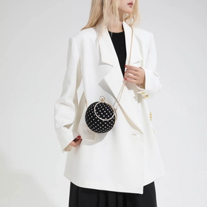 Polka dot mini spherical bag with gold chain and rhinestone handle on white suit
