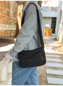 Detail of waterproof nylon messenger bag with orange label and adjustable shoulder strap