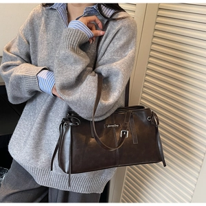 Detail of dark coffee matte leather pillow bag with drawstring and Sunny Day logo