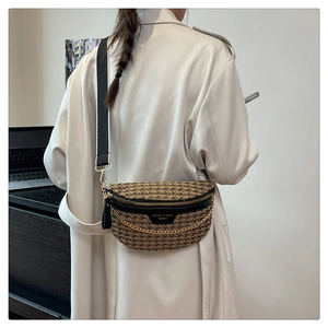 Detailed back view of a woven chest bag with broad strap and gold chain accent
