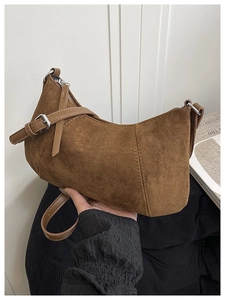 Detailansicht der braunen Wildledertasche mit silbernen Beschlägen und verstellbarem Riemen