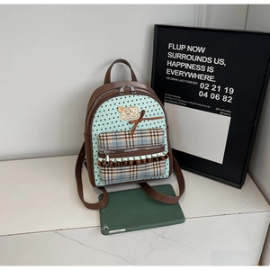 Detail of mint green star-patterned backpack with bow, plaid pocket and leather trim