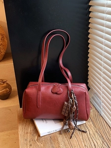 Retro reddish-brown cylinder shoulder bag with oil wax finish and charm detail