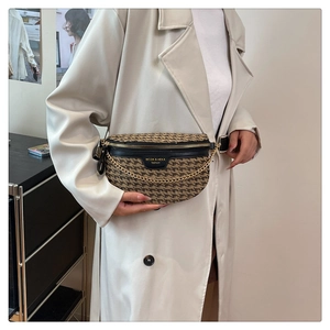 Detail of checkered crossbody bag with black leather flap and chunky gold chain strap