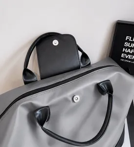 Dettaglio borsa da viaggio capiente con trama in nylon e chiusura magnetica in metallo