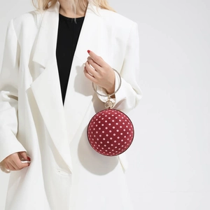 Detail of burgundy velvet ball bag with polka dots and rhinestone metal ring handle