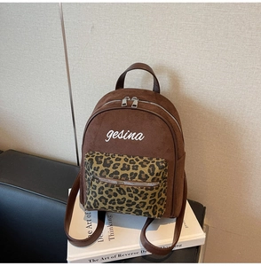 Nahaufnahme brauner Wildleder-Rucksack mit Leopardenmuster-Tasche und gesina-Stickerei