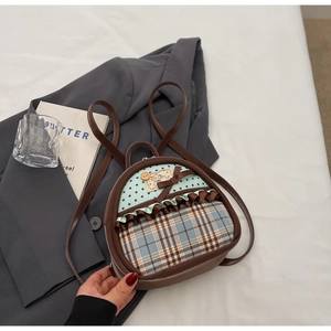 Detail of vintage mini backpack with brown PU leather, blue polka dots, and ribbon bow