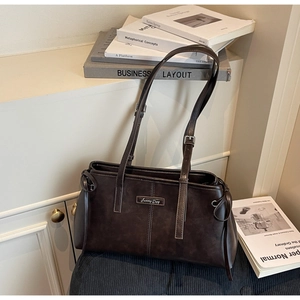 Detail of vintage dark brown frosted shoulder bag with adjustable straps and side ties