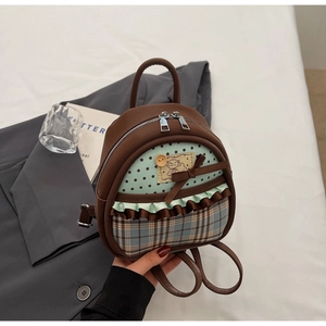 Close-up of patchwork mini backpack featuring bow details and ruffled trim accents