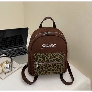 Detail eines braunen Wildleder-Rucksacks mit Leoparden-Tasche und gesina-Stickerei