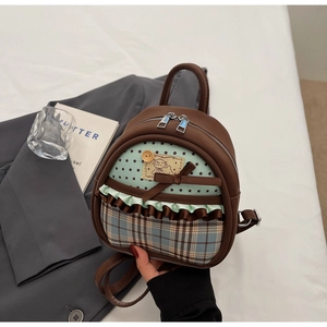 Detail of cute mini backpack featuring stars, plaid patterns, and a lovely bow decoration
