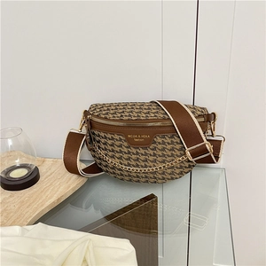 Close-up of houndstooth crossbody bag with gold zipper and wide fabric strap
