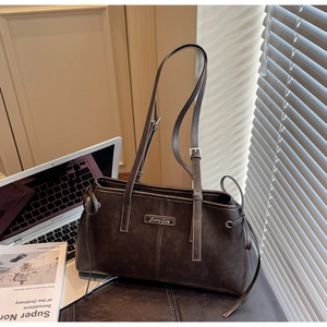 Macro detail of vintage brown faux leather tote bag with Funny Day metal plate and stitching