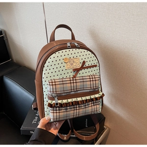 Detail view of mini bow backpack showing plaid pocket and cute lamb patch decoration
